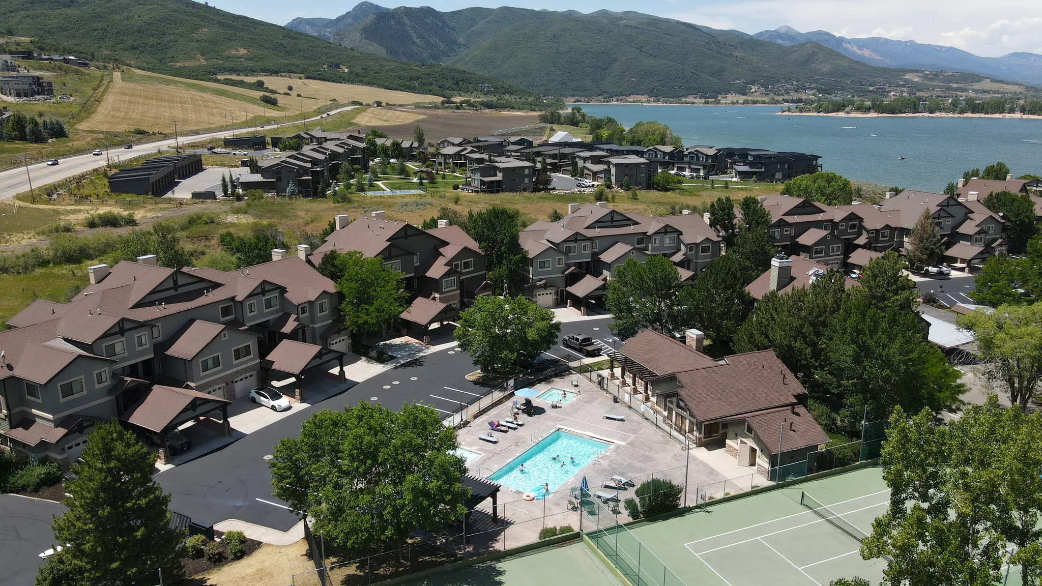 Aerial overview showcasing a residential development with a community pool and tennis court