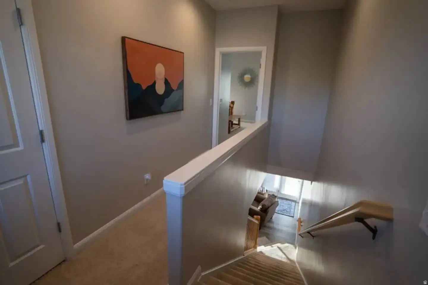 Carpeted landing with neutral wall tones and white trim