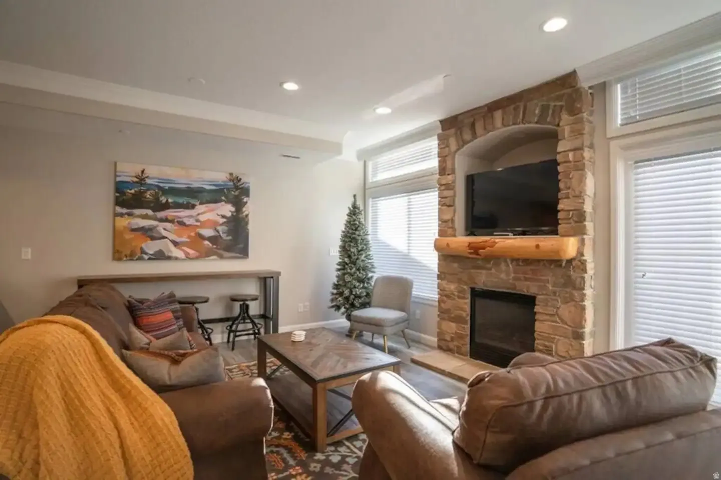 Stone fireplace with a log mantel and integrated media niche
