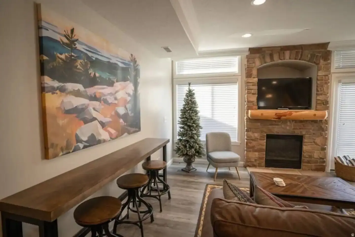 Living area featuring a stone-clad fireplace with a log mantel, a built-in media niche, and recessed lighting