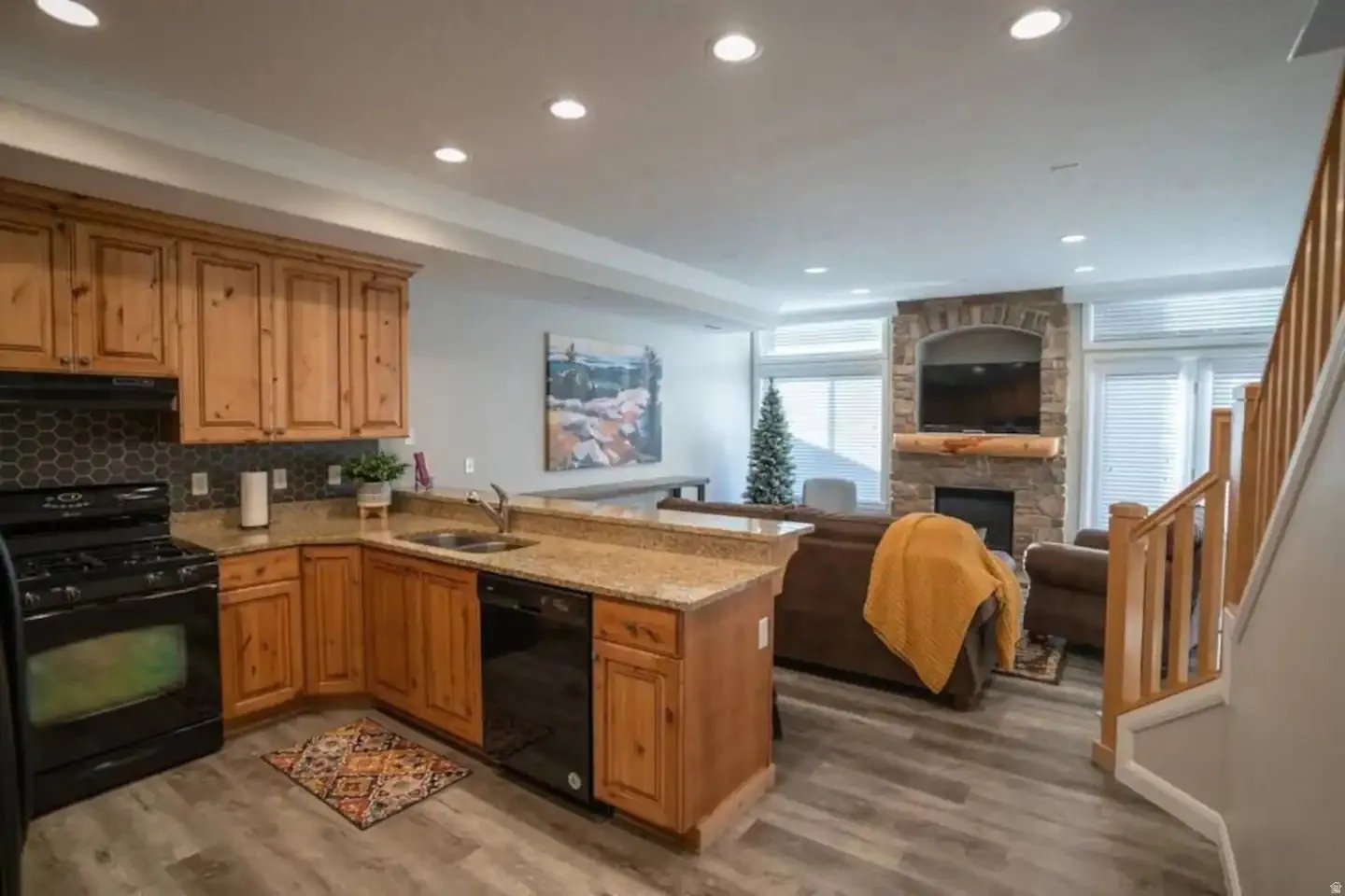 Open-concept living area with a kitchen island featuring granite countertops and wood cabinetry