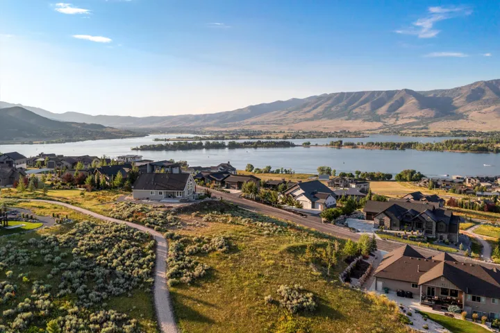 Expansive aerial perspective showcasing residential properties with a prominent lake and mountainous landscape
