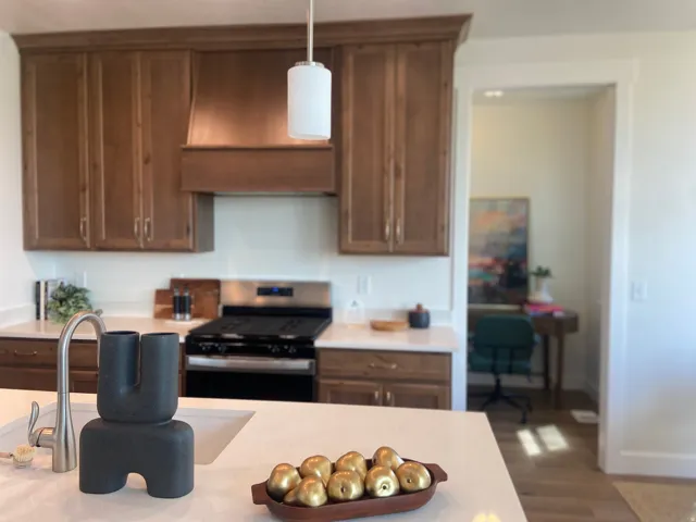 Kitchen featuring wood cabinetry, stainless steel range, and a built-in ventilation hood