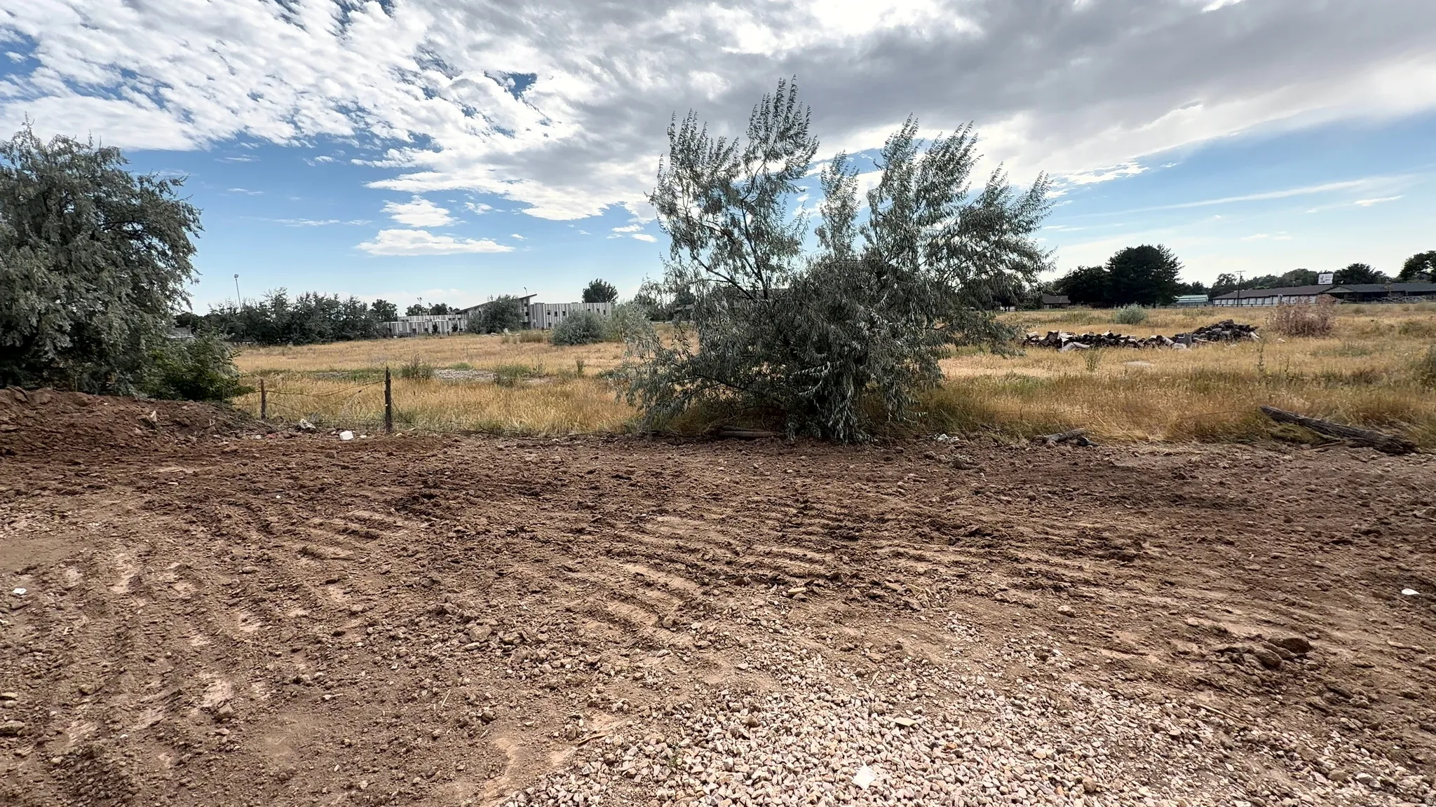 Backyard of townhomes before landscaping with Greenwood Charter School in the background