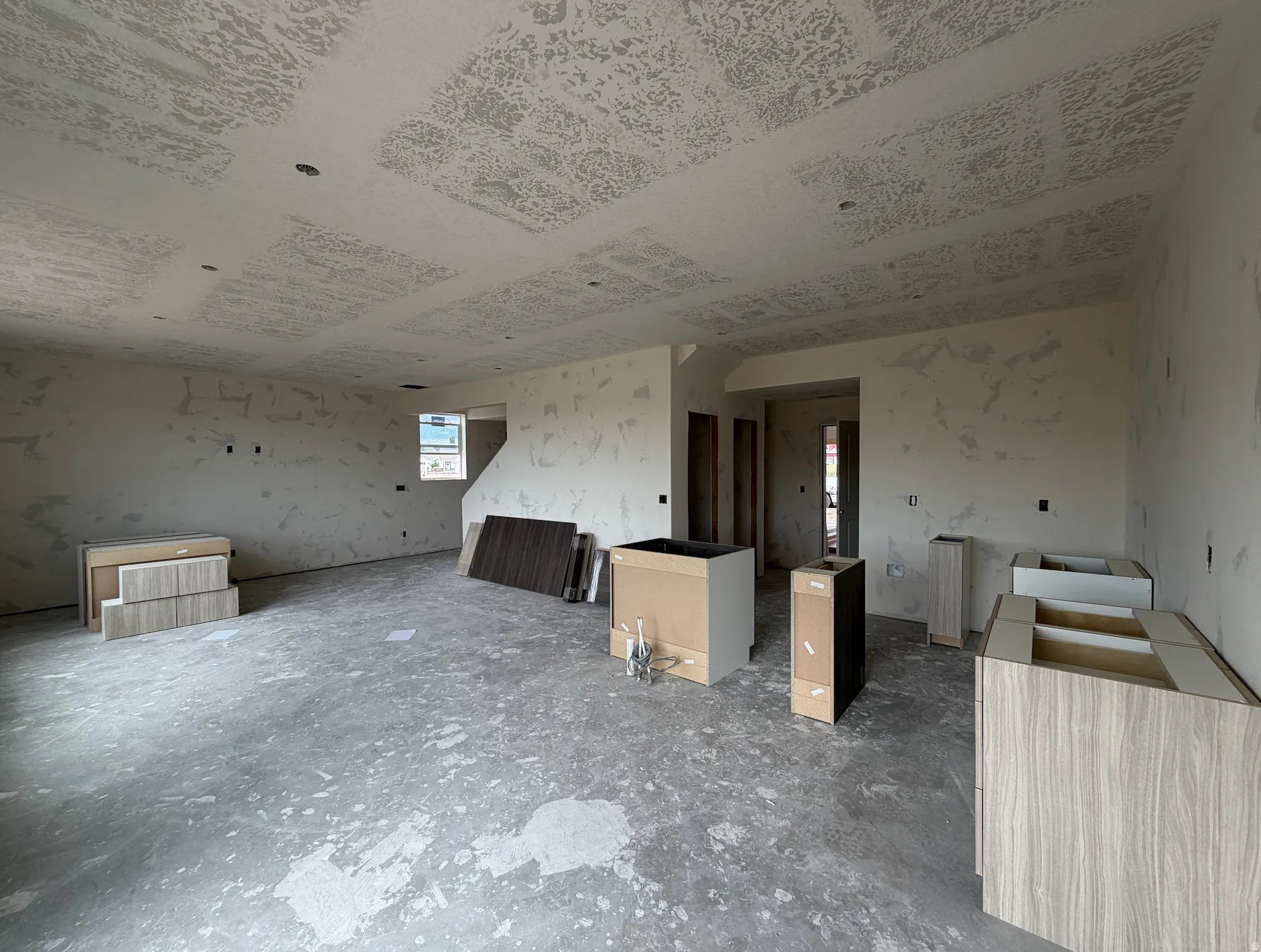 Open-concept interior featuring a window, recessed lighting, and partially installed cabinetry