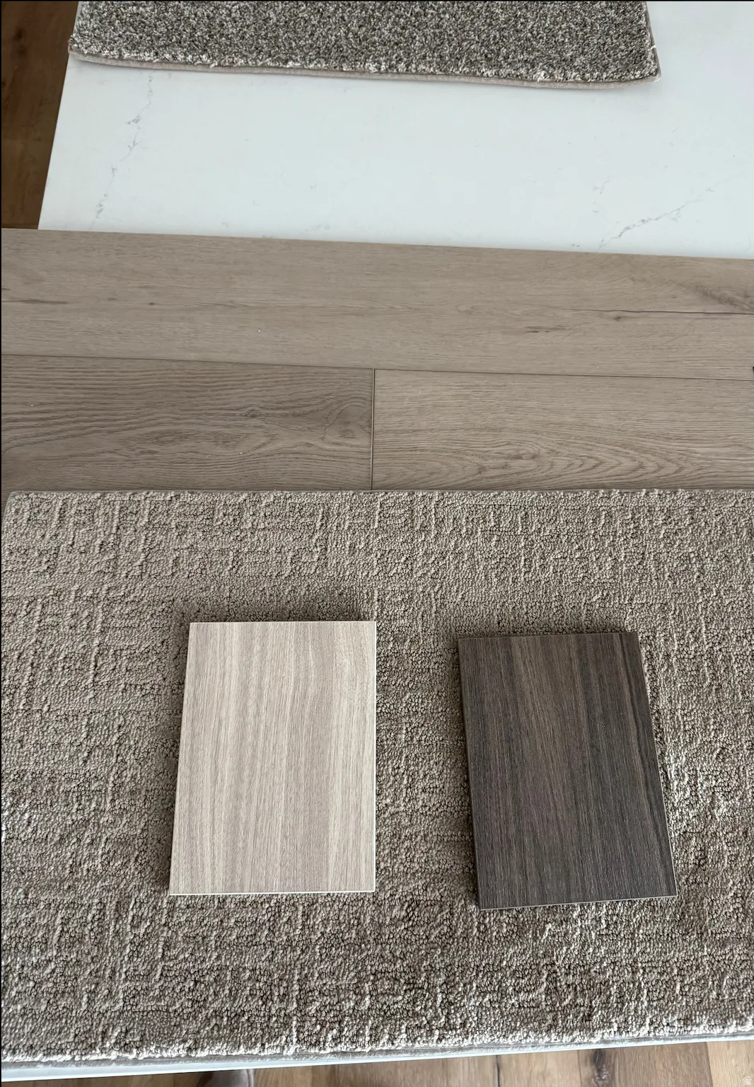 Lots 7, 9, and 11 will have two-toned kitchens. The lighter color will be used for the kitchen cabinetry, except the island, which will be the darker color. The bathrooms in these units will also have the darker cabinet color. The white countertop with li