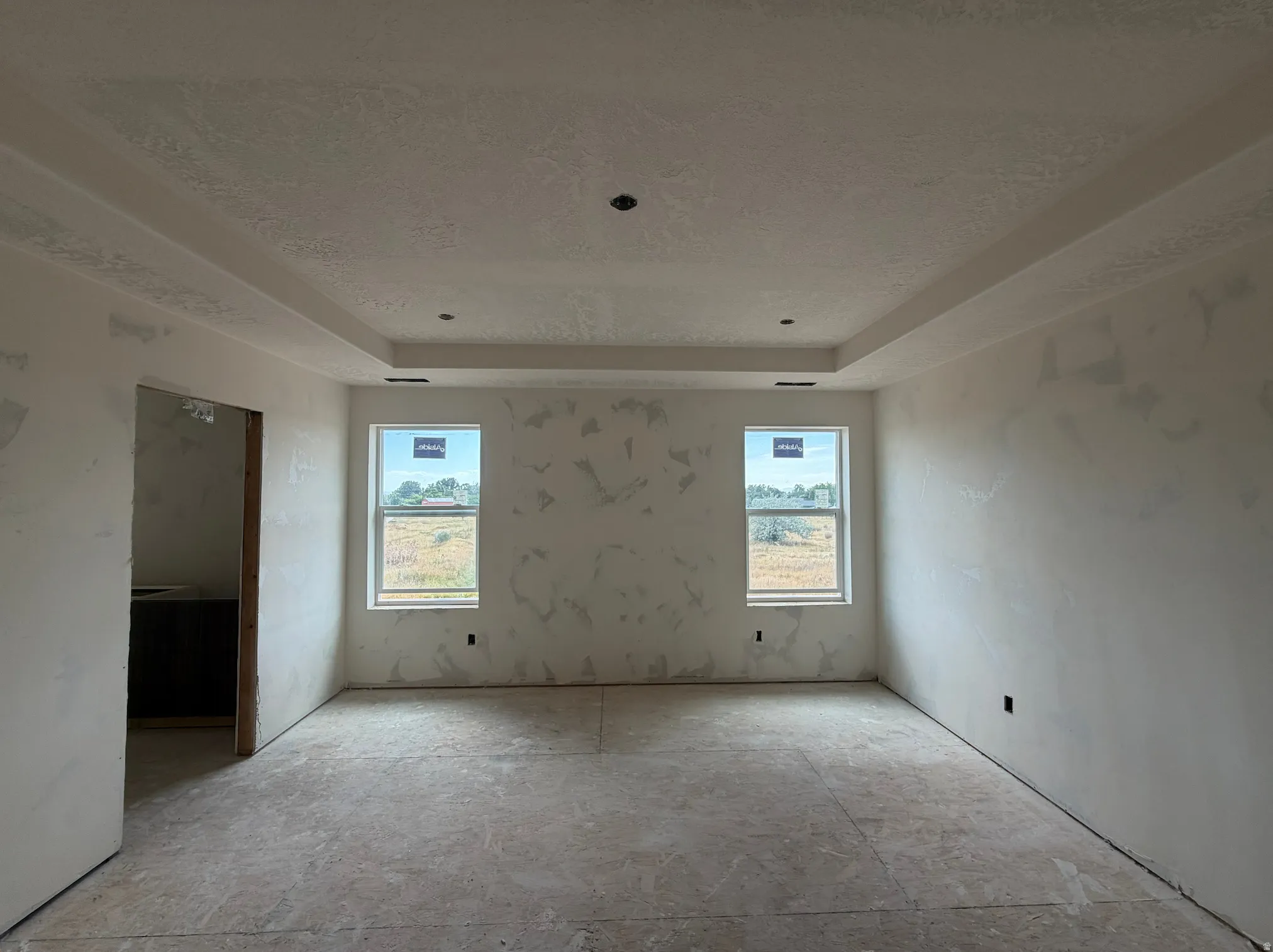 Primary bedroom with tray ceiling, can lighting, and space for a ceiling fan.