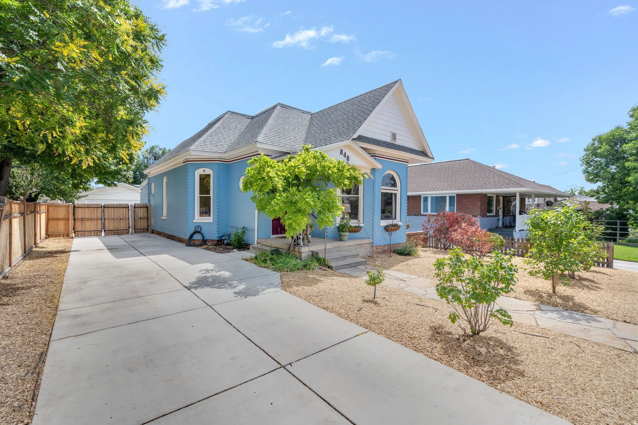 Pale blue exterior with white trim, arched windows, and a prominent front gable