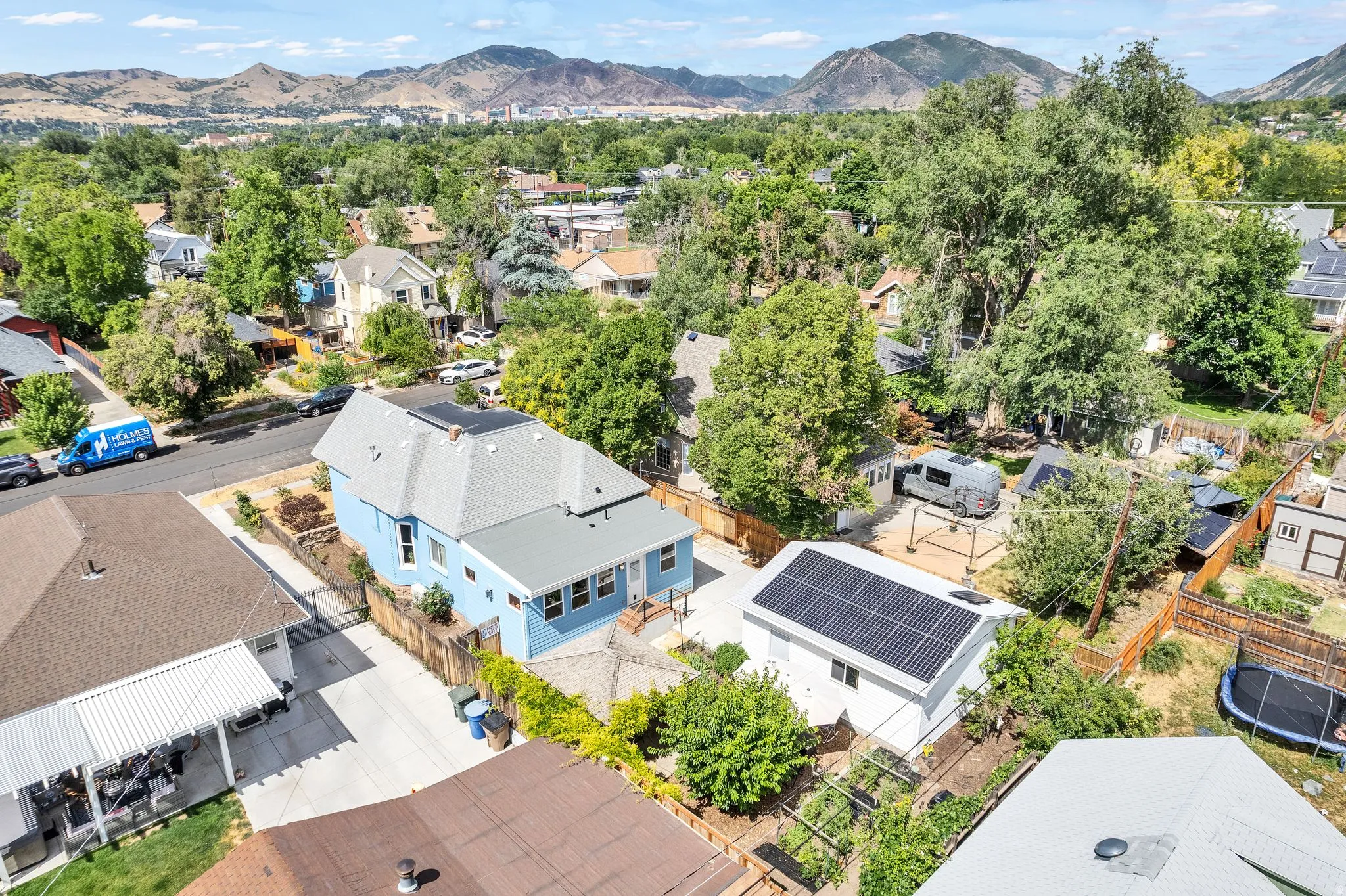 Blue exterior residence featuring a light gray shingle roof with solar panels