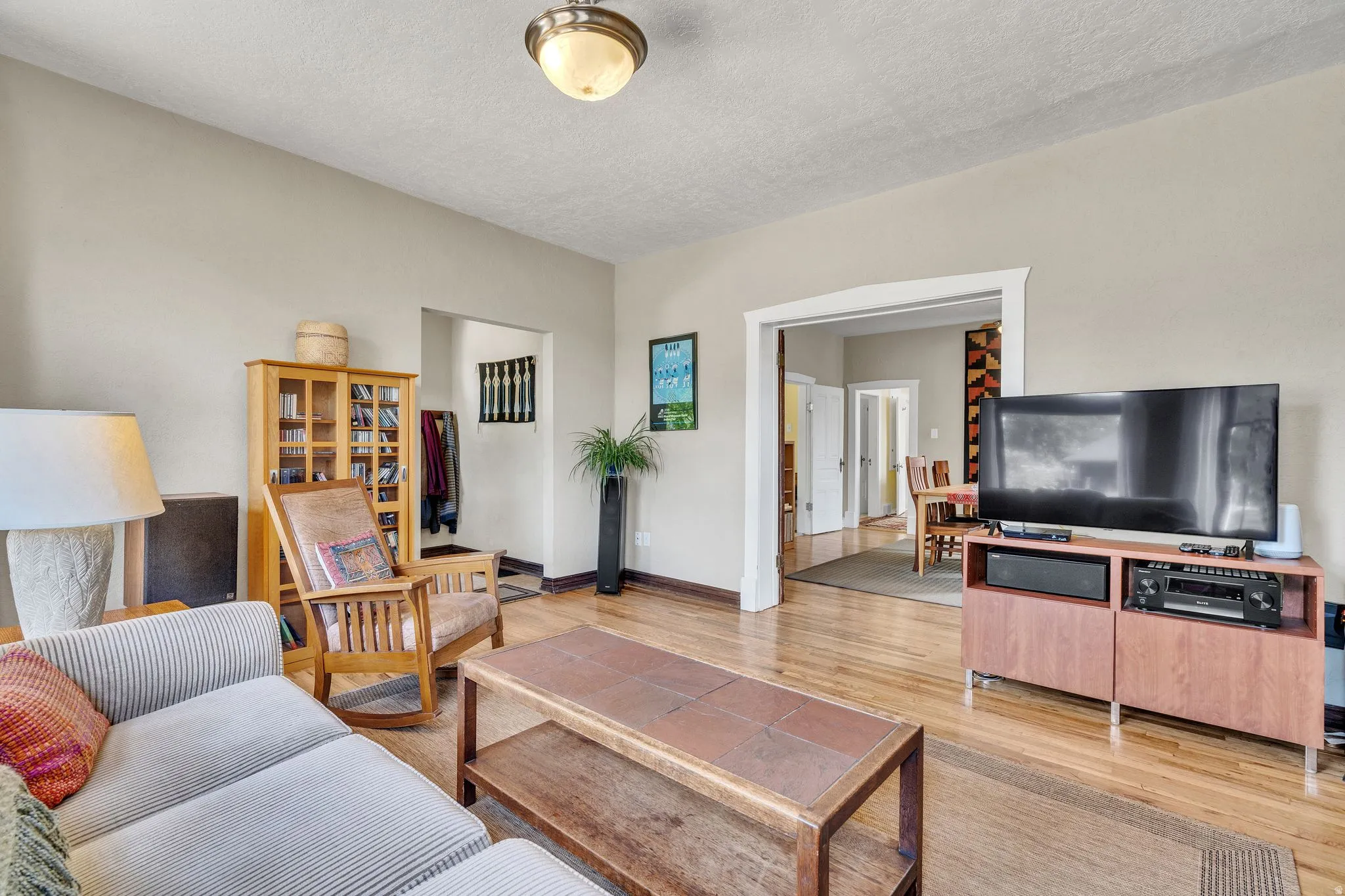large Light-filled formal living room with beautiful hardwood floors, lots of natural light and an arched doorway leading to adjoining dining room