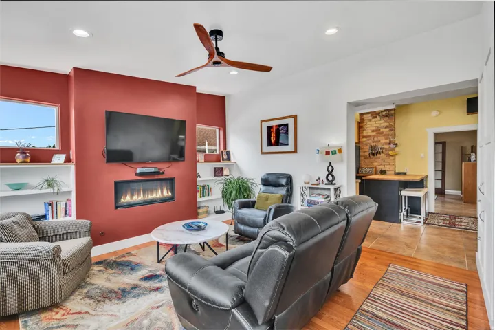 Living area with a modern linear fireplace, recessed lighting, and a ceiling fan
