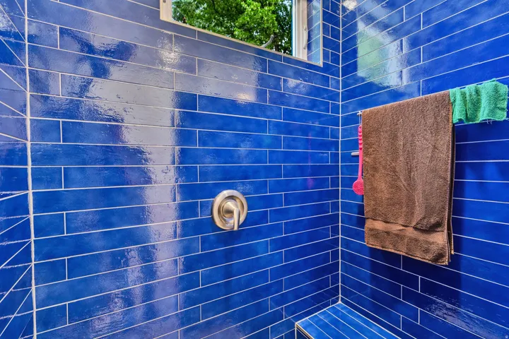 Shower enclosure featuring blue subway tile