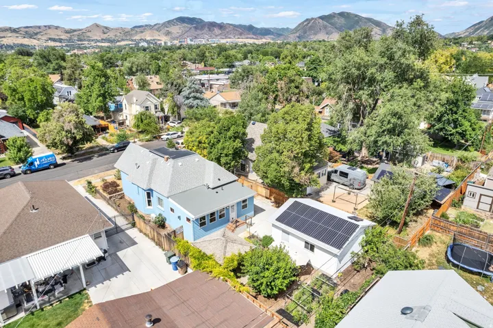 Blue exterior residence featuring a light gray shingle roof with solar panels