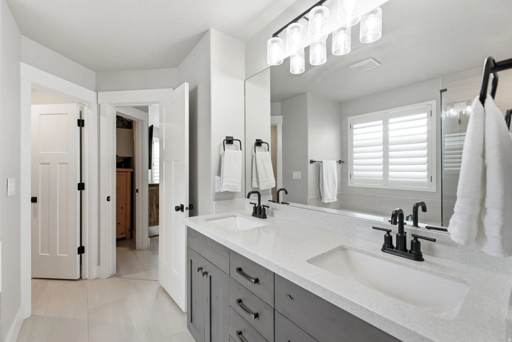 Double vanity with dual undermount sinks, stone-finish countertop, and matte black faucets