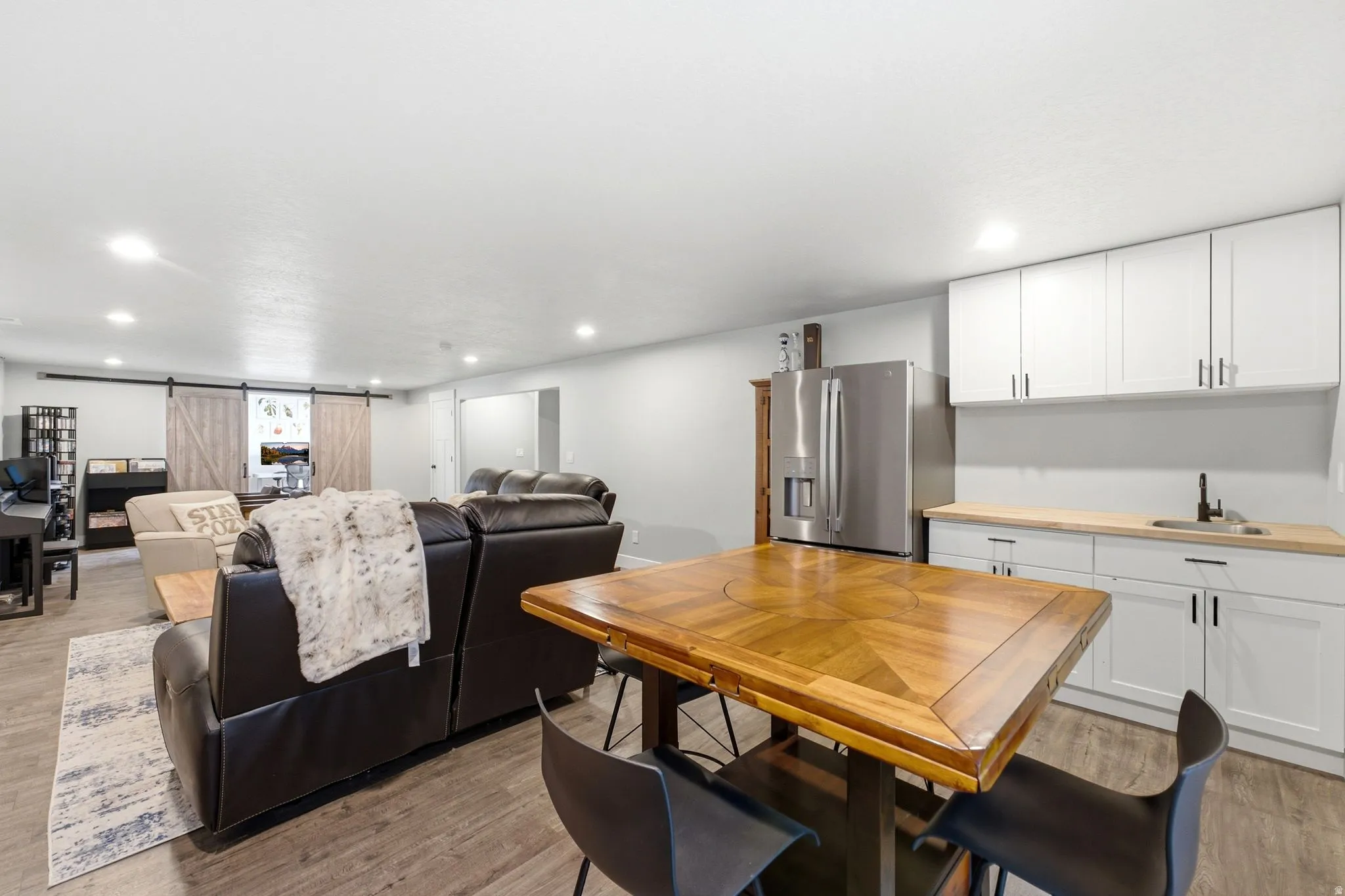 Open concept living area featuring wood-finish flooring, recessed lighting, and a barn door entry