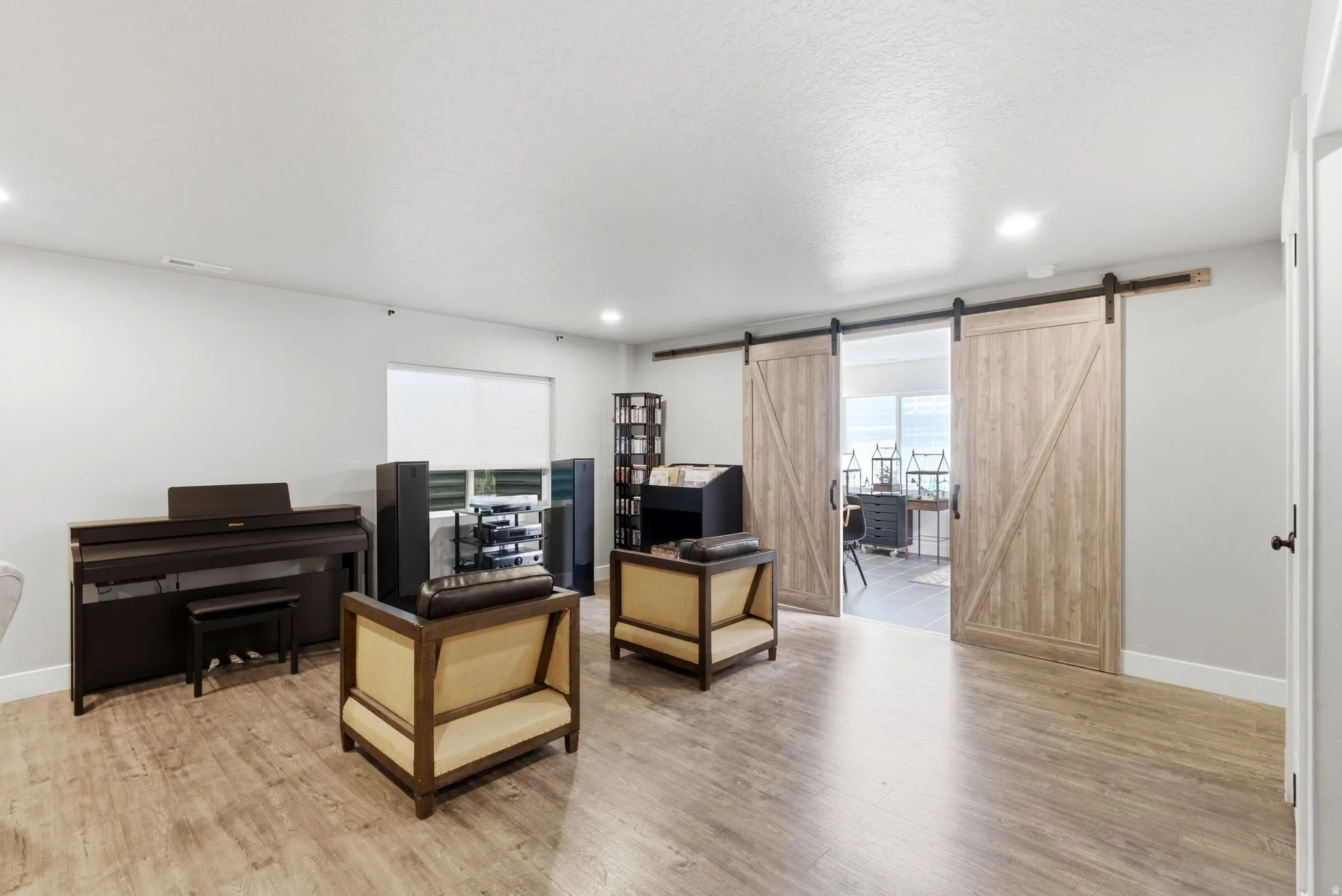 Spacious room featuring wood-finish flooring and recessed lighting
