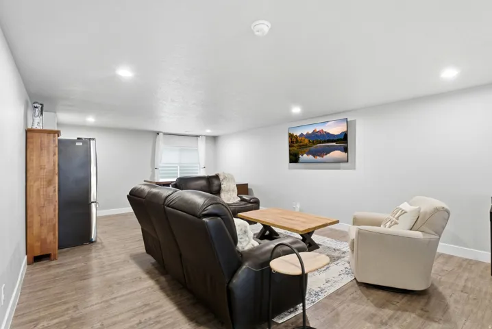 Spacious room featuring wood-finish flooring, recessed lighting, and a neutral color palette