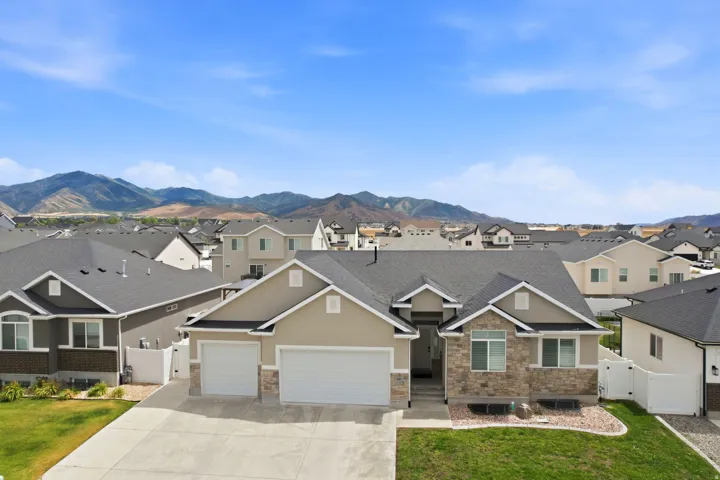 Modern ranch-style home featuring a stone and stucco exterior, two-car garage, and established landscaping