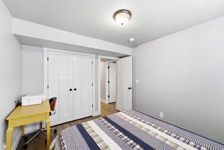 Interior room featuring wood-finish flooring, white paneled doors, and a flush mount ceiling light fixture