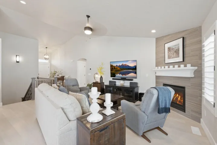Living space featuring a corner fireplace with a tiled surround and white mantel