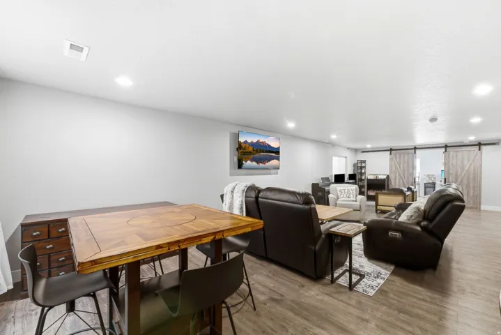 Spacious open-concept room featuring wood-finish flooring, recessed lighting, and light gray walls