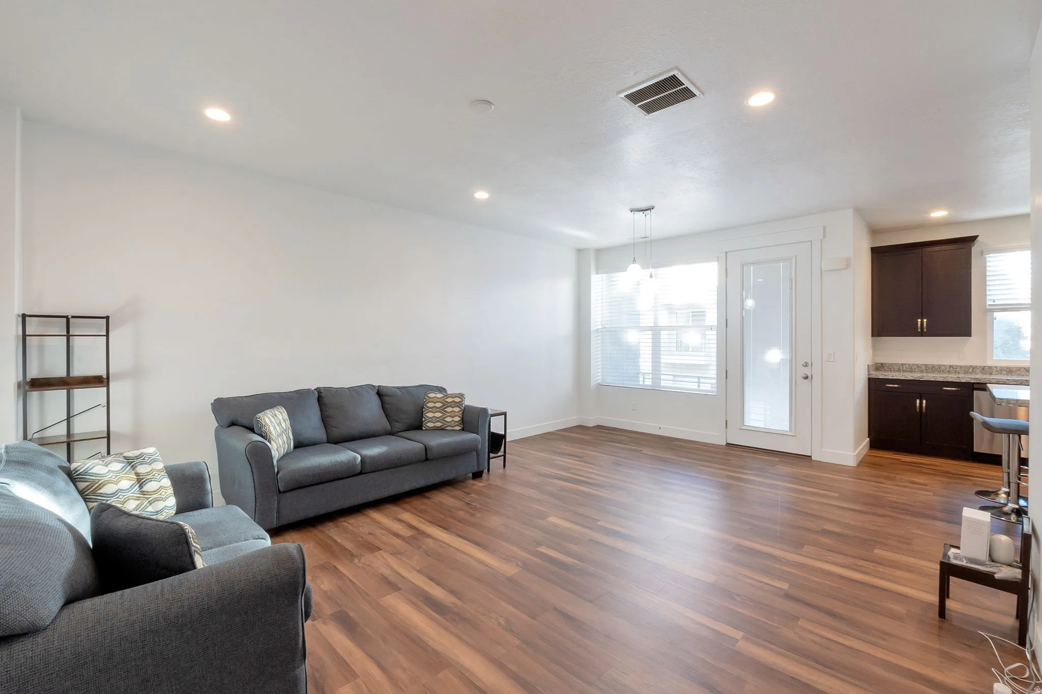 Wood-finish flooring throughout, recessed lighting, and a glass-paneled door