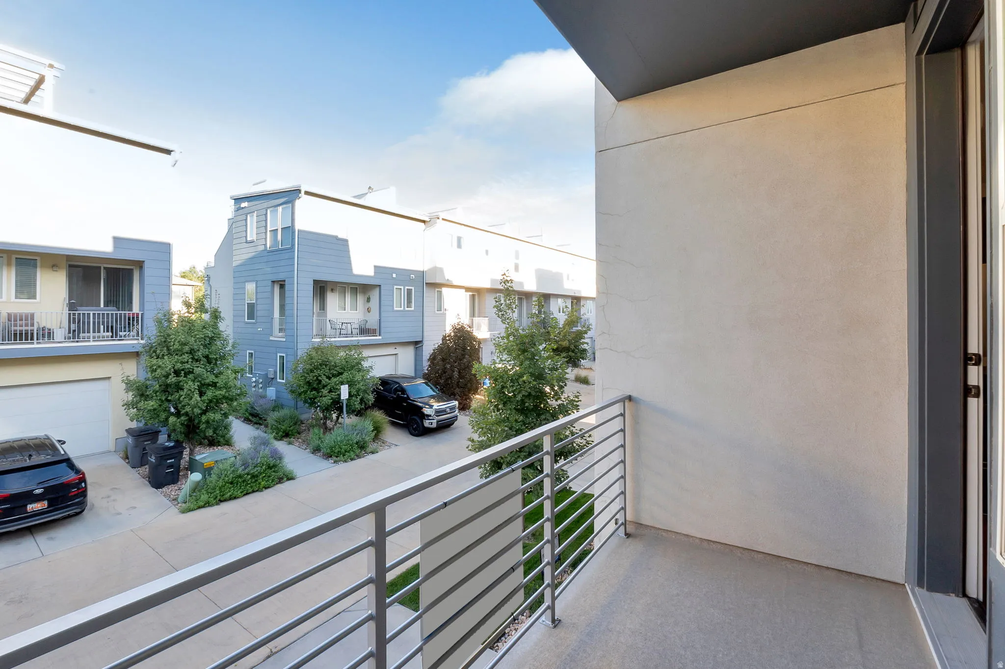 Private balcony with a concrete surface and horizontal metal railing