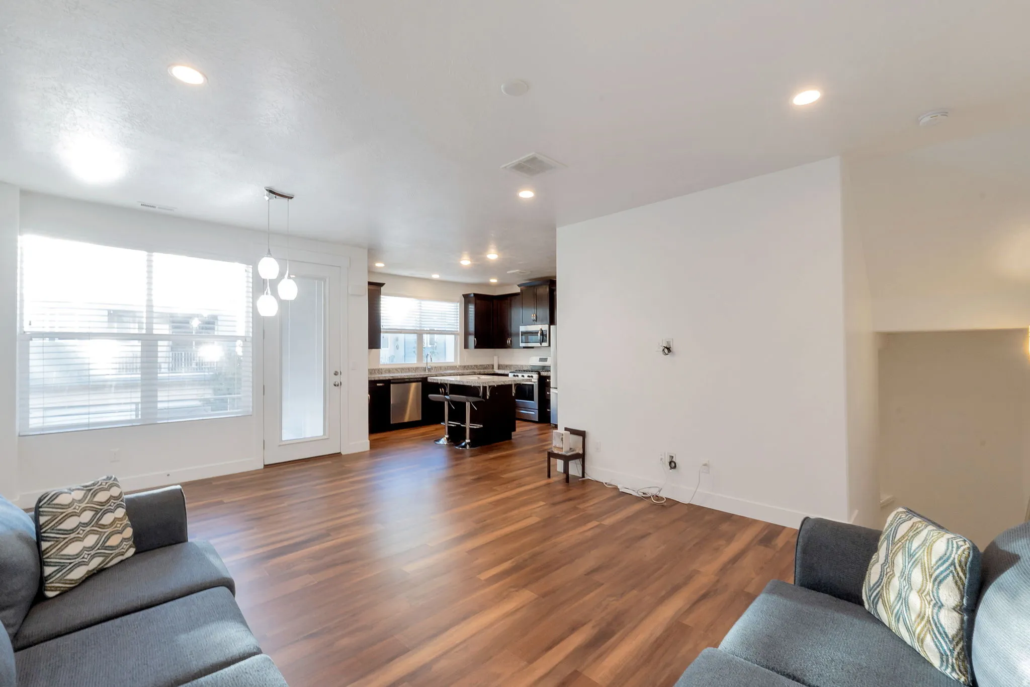 Expansive wood-finish flooring, recessed ceiling lighting, and a modern pendant fixture