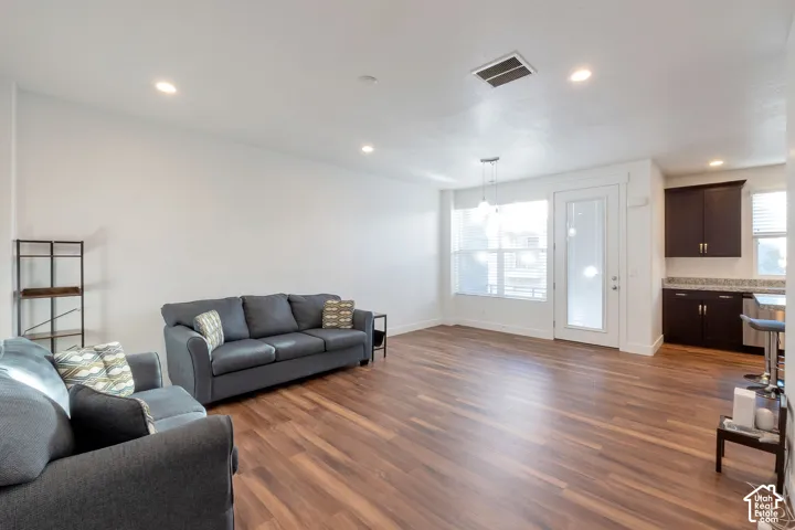 Wood-finish flooring throughout, recessed lighting, and a glass-paneled door