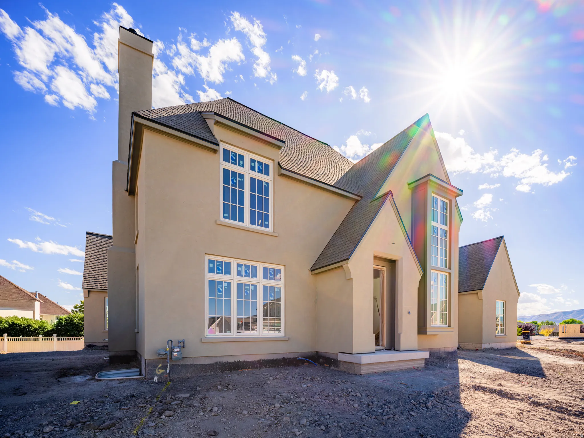 Stucco exterior with multiple gables and a prominent chimney