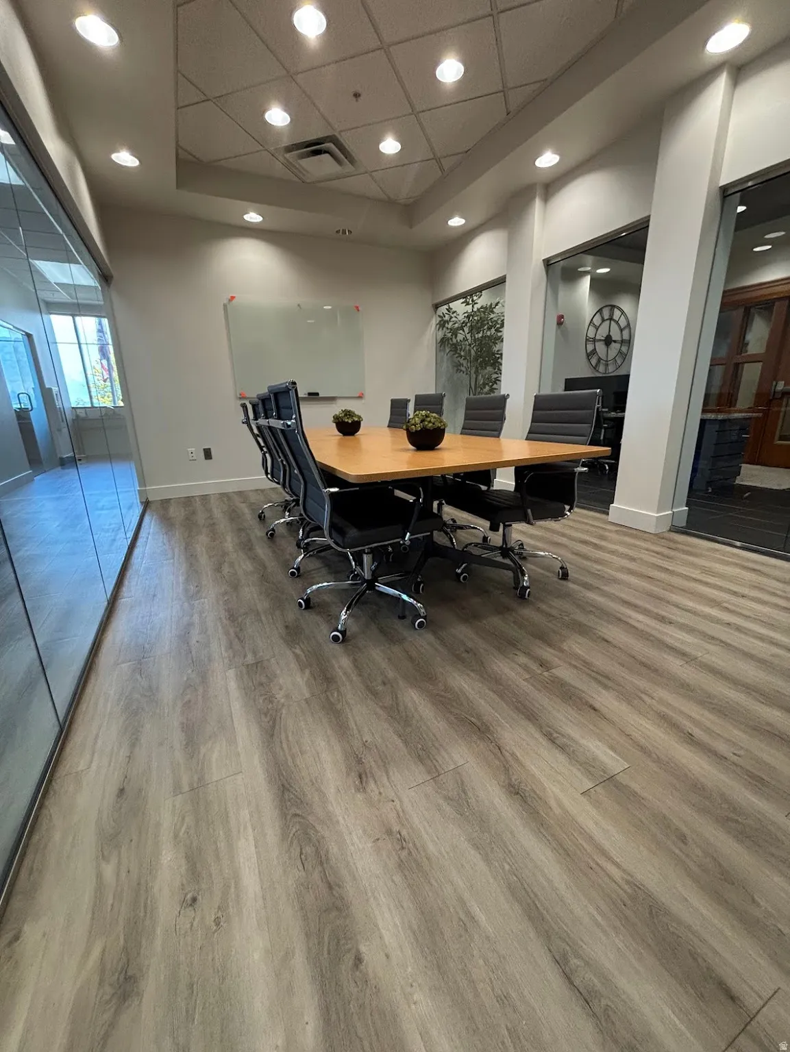 Conference room featuring wood-finish flooring, recessed lighting, and a white presentation board