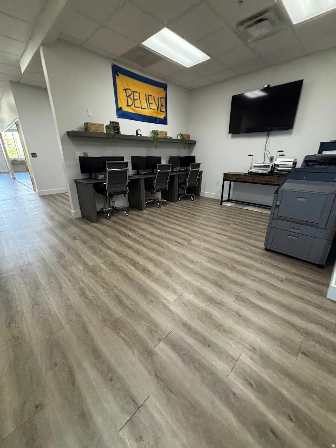 Bullpen featuring three workstations and space for a printer or other machinery.