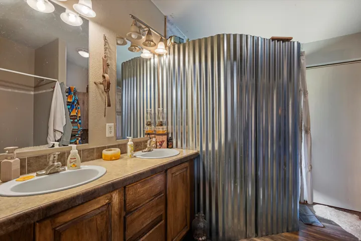 Bathroom featuring a dual vanity with integrated sinks and wood-finish cabinetry