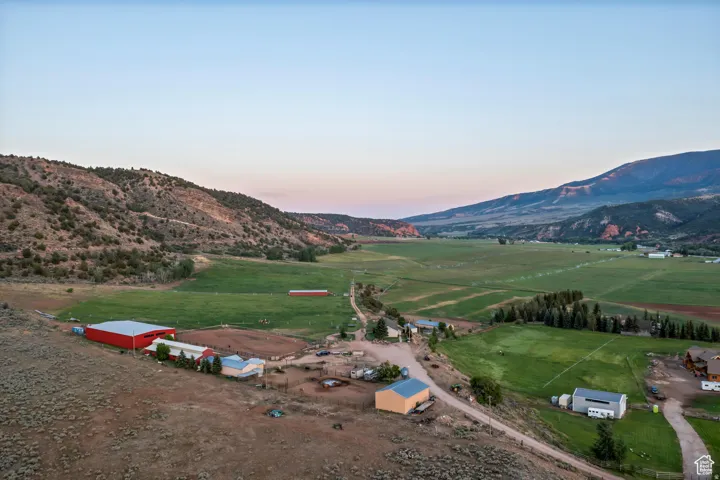 Expansive rural property featuring multiple structures, including a large red barn, smaller outbuildings, and residential structures
