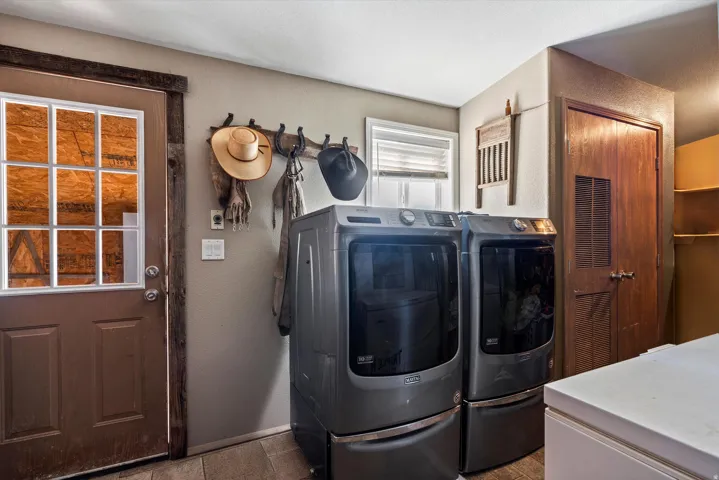 Laundry area featuring wood-finish flooring, a six-pane windowed door, and built-in shelving