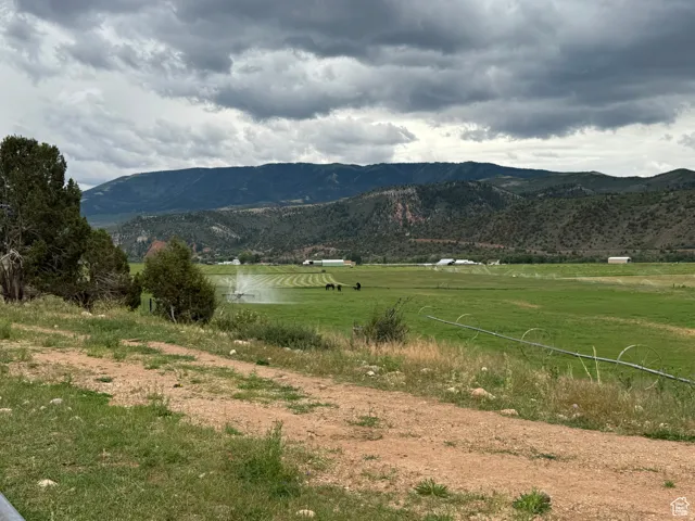 Expansive green pastureland with distant mountain ranges