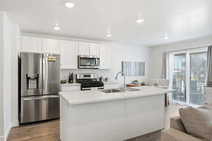 Contemporary kitchen featuring white cabinetry and stainless steel appliances