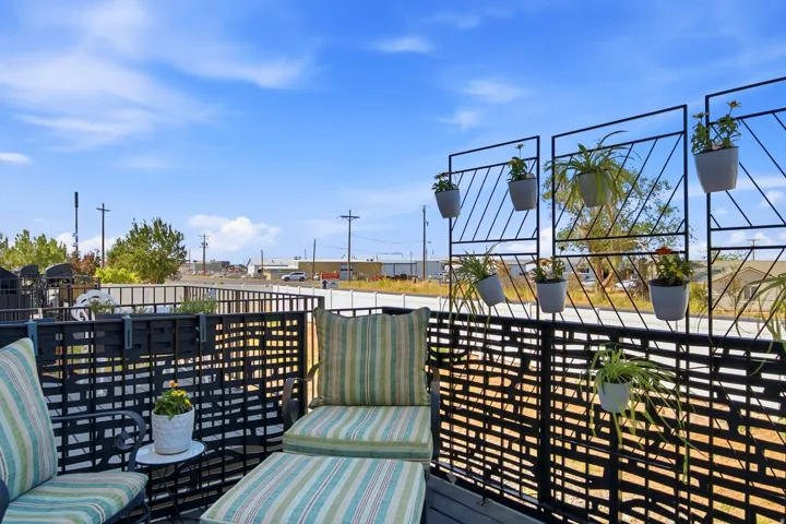 Outdoor deck space featuring black lattice fencing and a decorative metal trellis with integrated planters
