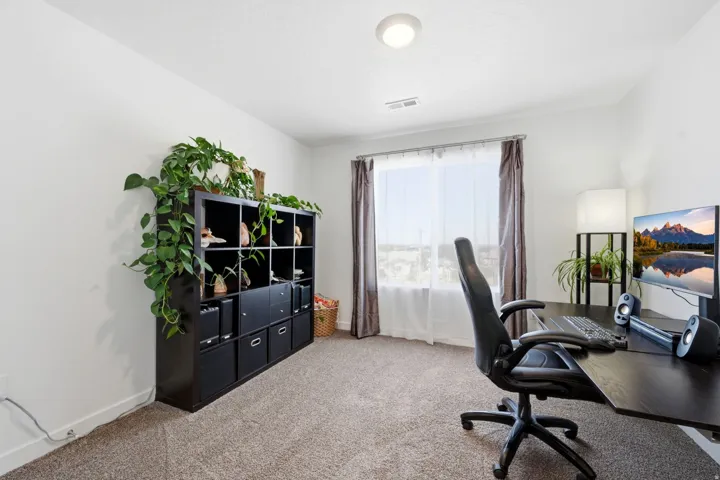 Carpeted room with a rectangular window, white walls, and a ceiling-mounted light fixture
