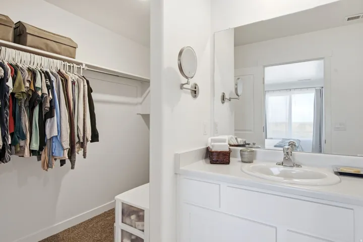Bathroom vanity with a rectangular mirror and white countertop featuring an integrated sink with a chrome faucet