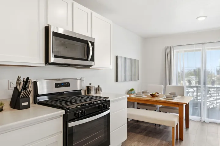 Contemporary kitchen featuring white cabinetry, stainless steel appliances, and a light-toned countertop