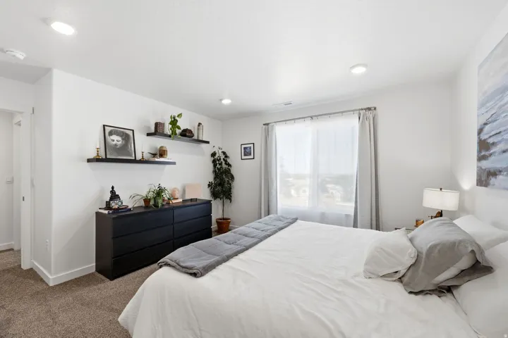 Spacious room featuring carpeting, recessed lighting, white walls, and a large window with sheers and drapes