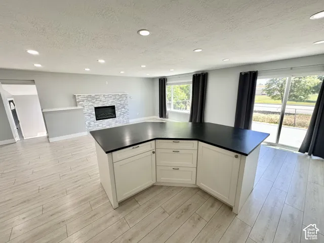 Contemporary kitchen island with dark countertop and white cabinetry