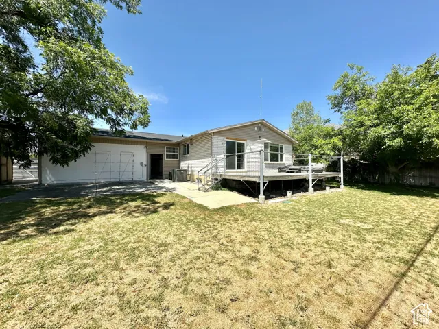 Rear exterior featuring a spacious elevated deck, sliding glass doors, and a detached structure