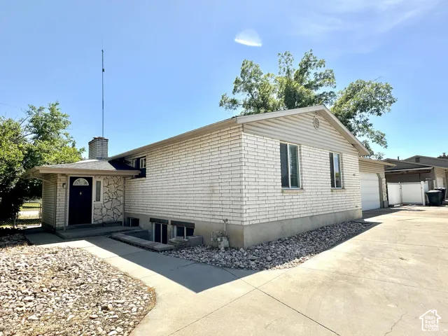 Exterior features include light brick siding, a stone facade entry, a paved driveway, and a two-car garage