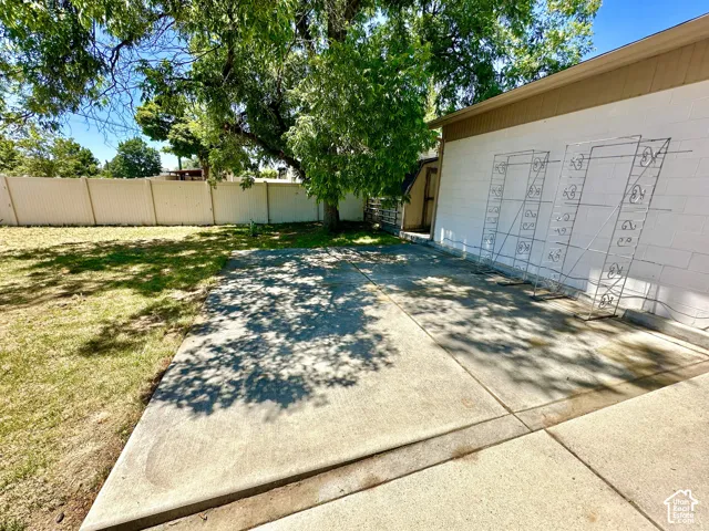 Expansive concrete patio area with a white painted exterior wall