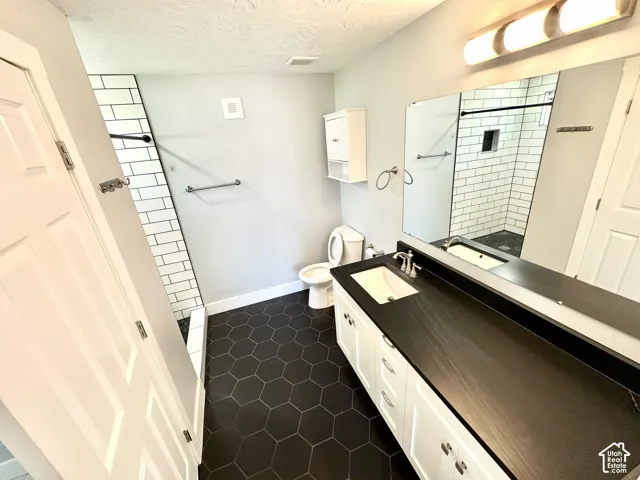 Bathroom featuring a dual-sink vanity with a dark countertop and undermount sinks
