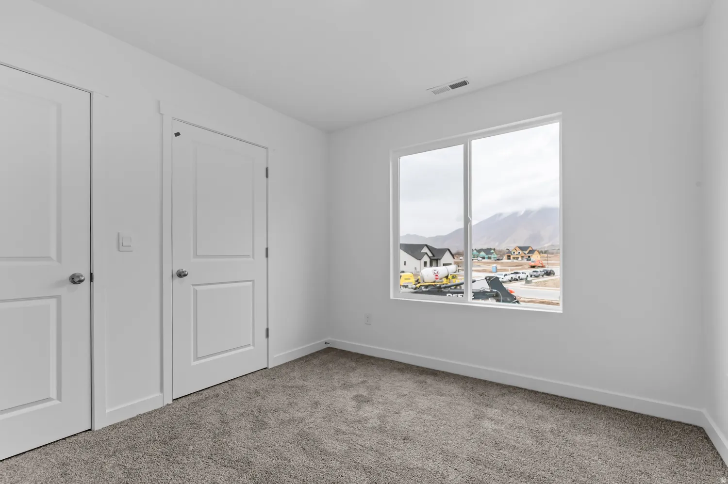 Room featuring plush gray carpet, a two-panel window, white walls, and white trim