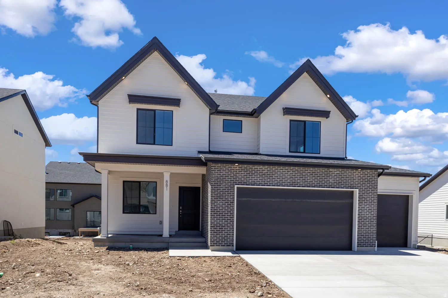 Modern exterior with white siding and dark brick accents