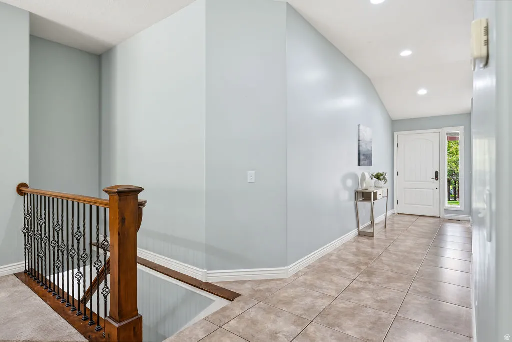 Entryway featuring a white paneled door with sidelight, recessed lighting, and tile flooring
